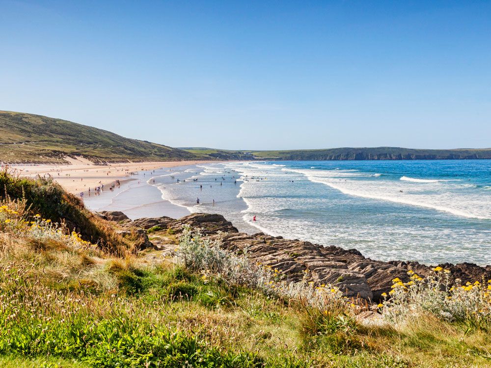 People on beach in Devon, the U.K., seen from cliff overlook