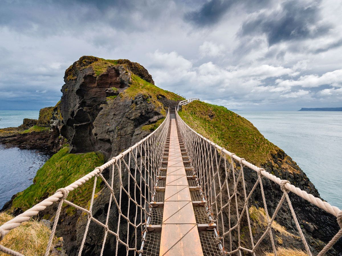 Pedestrian suspension bridge on rocky coastline of Great Britain