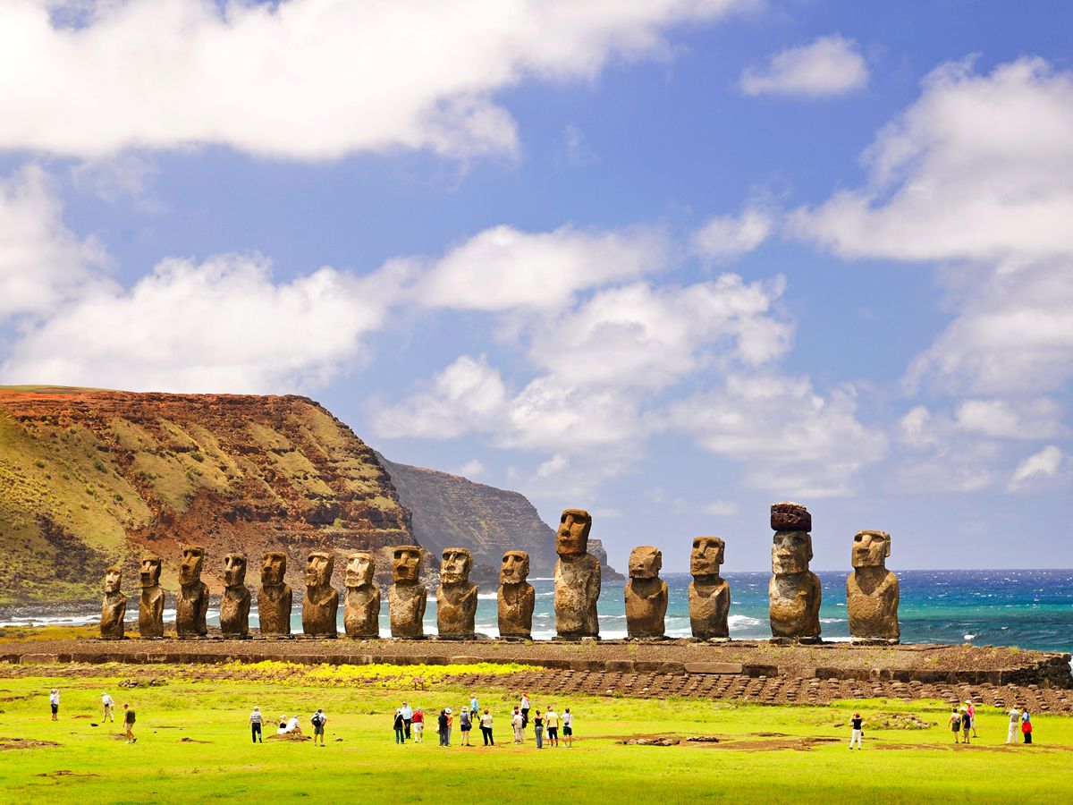 Easter Island moai statues with backs to sea and onlookers