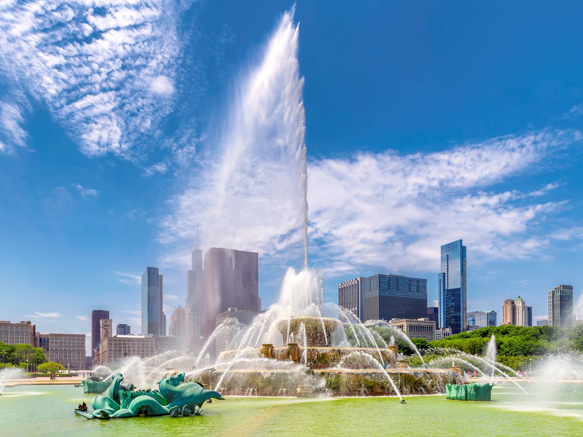 Water from Buckingham Fountain shooting high into the air with Chicago skyline in background