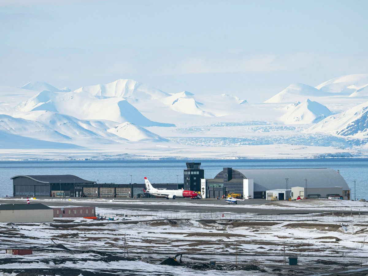 Overview of runway and terminal of Svalbard Airport in Norway, with snow-covered mountains in background