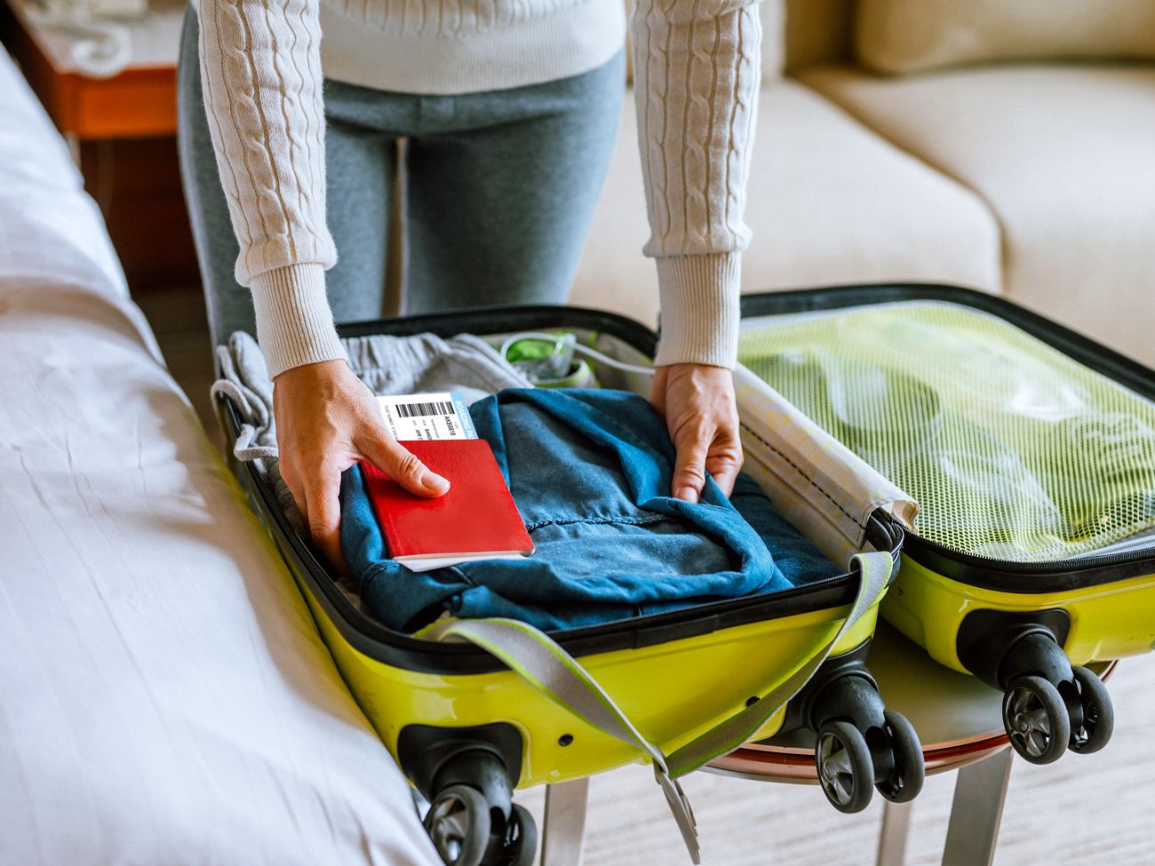 Traveler packing suitcase with passport, airline ticket, and clothing