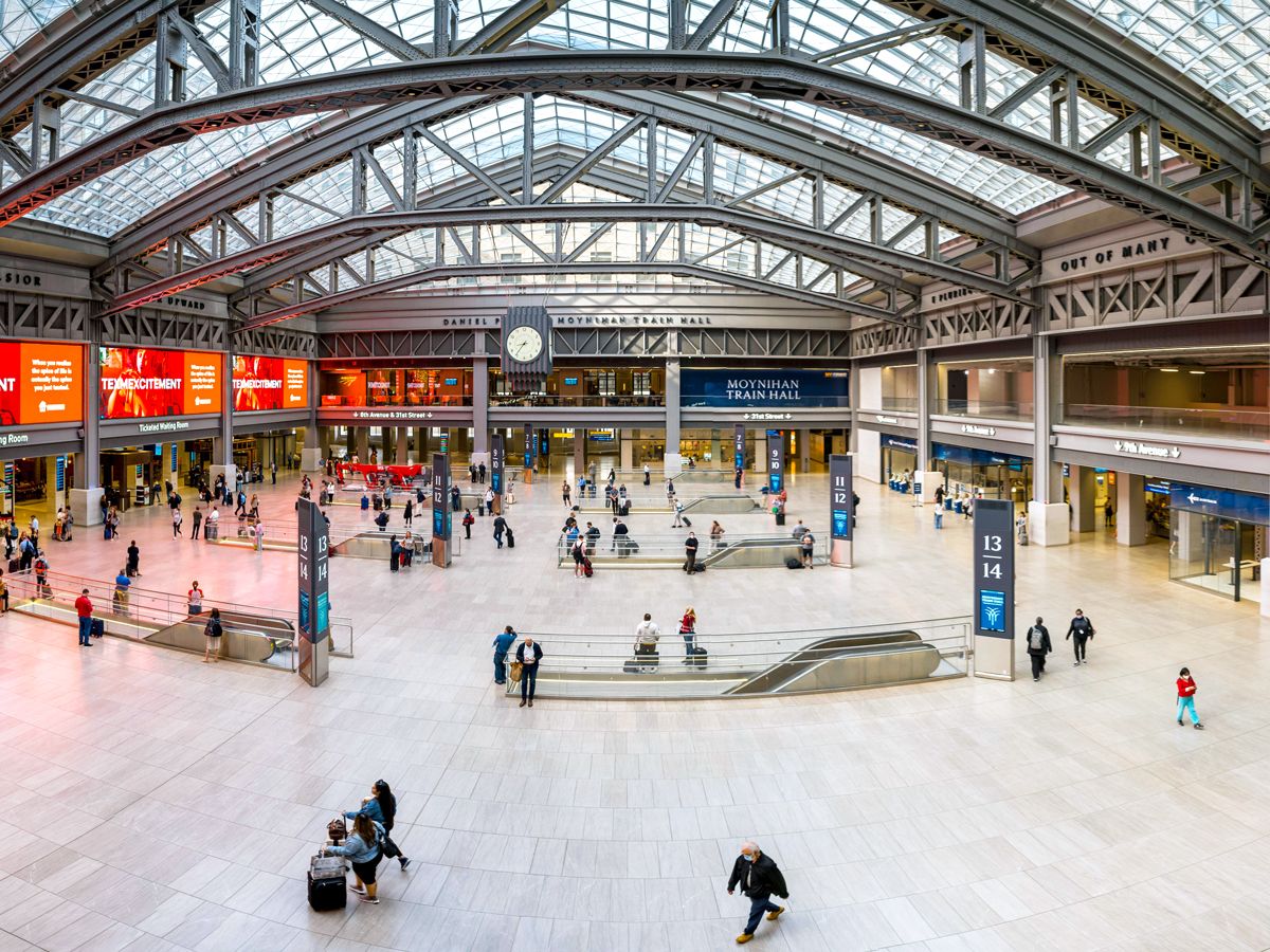 Commuters in light-filled interior of Moynihan Train Hall in New York City