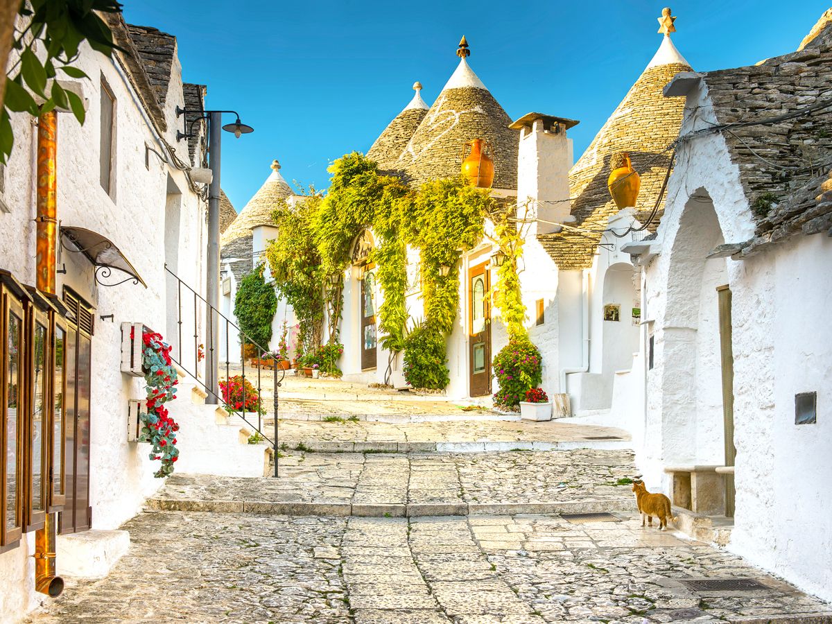 Cobblestone street lined with white houses in Puglia, Italy