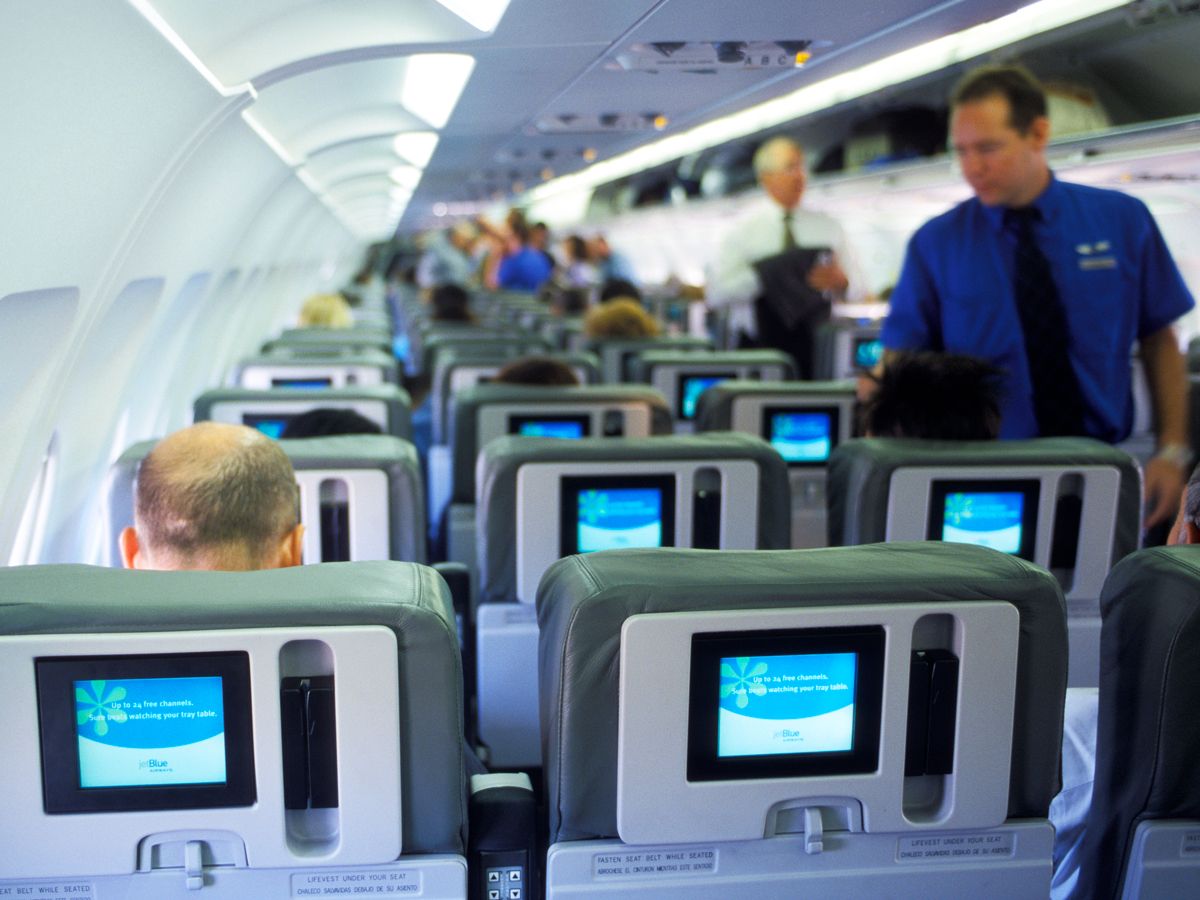 Flight attendant walking through aircraft cabin