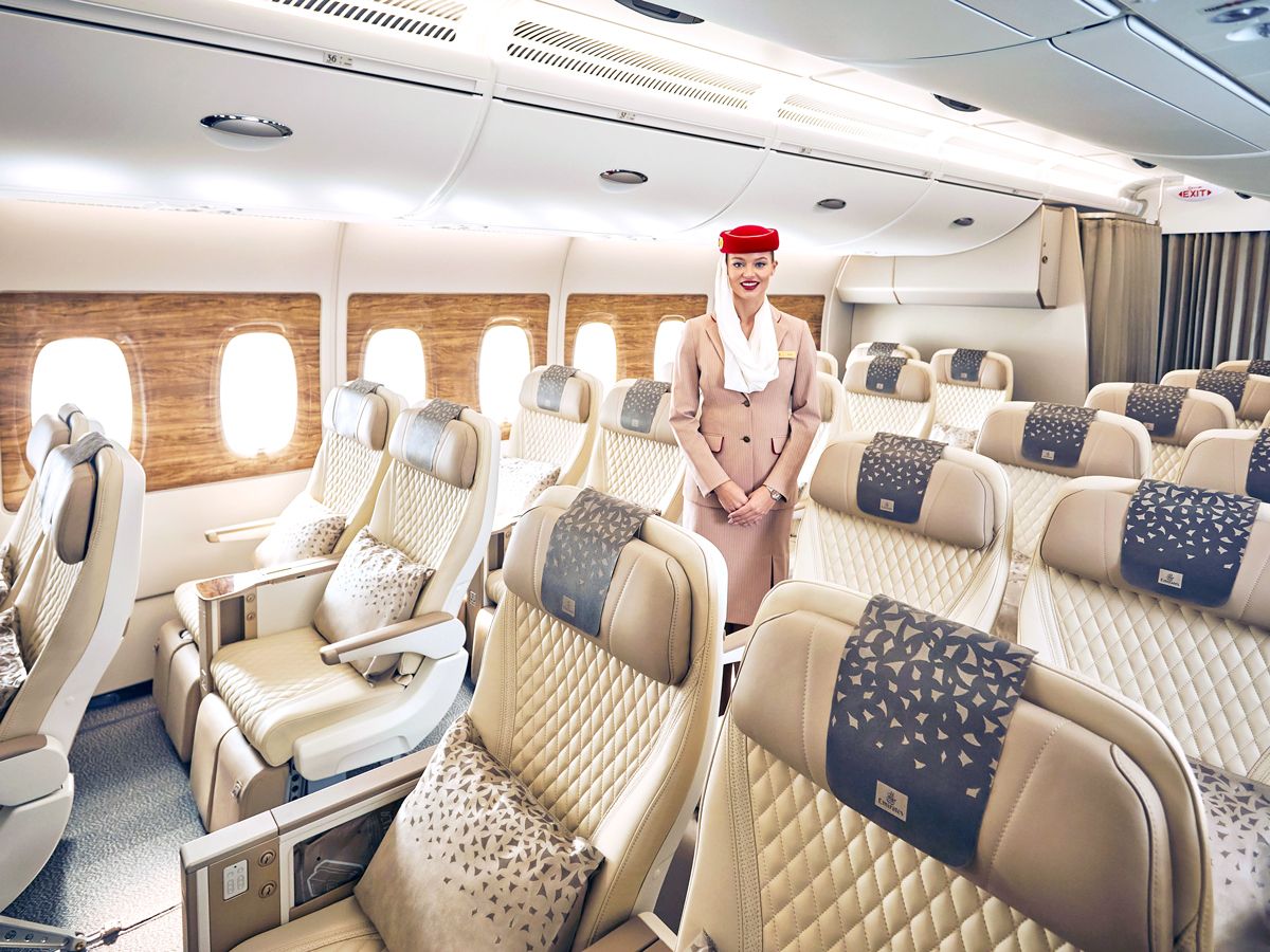 Flight attendant standing in Emirates cabin