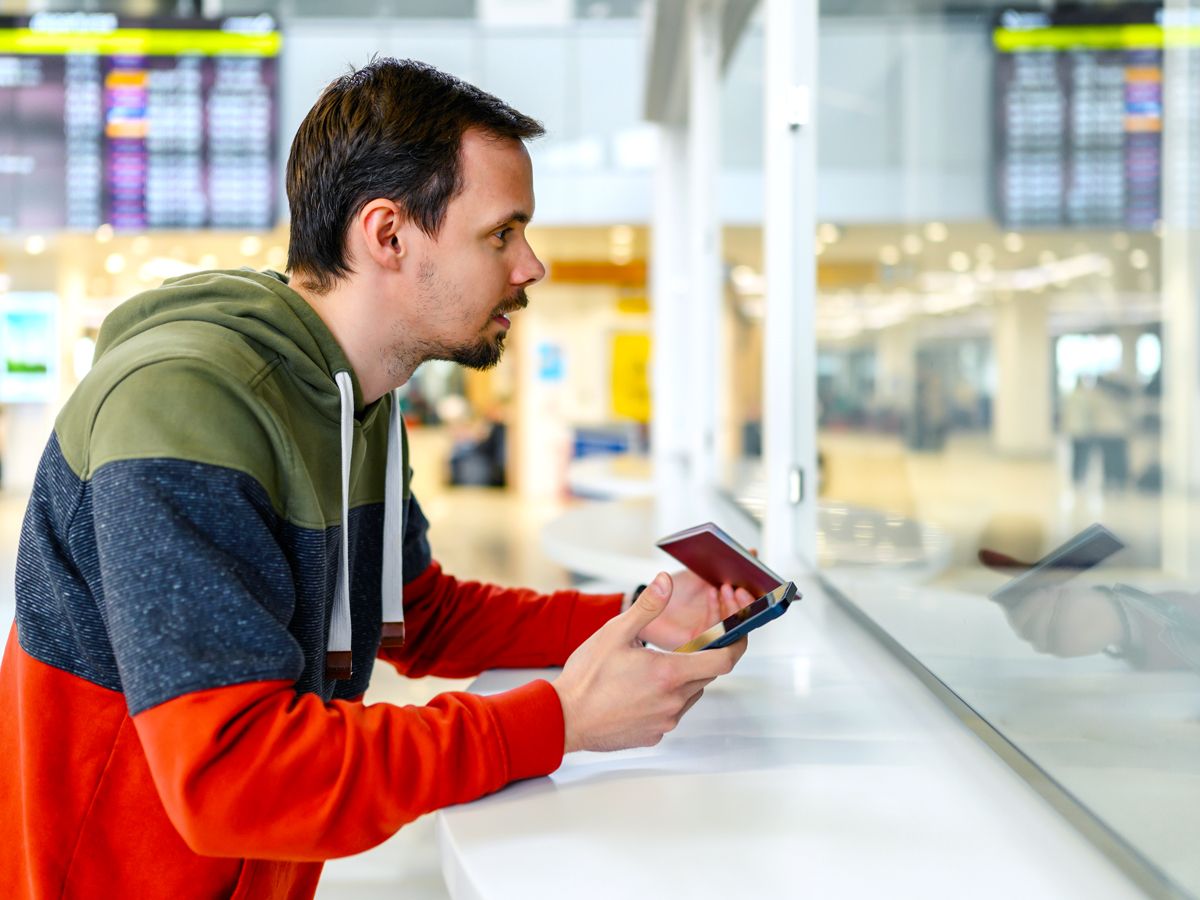 Airline passenger speaking with customer service agent at airport