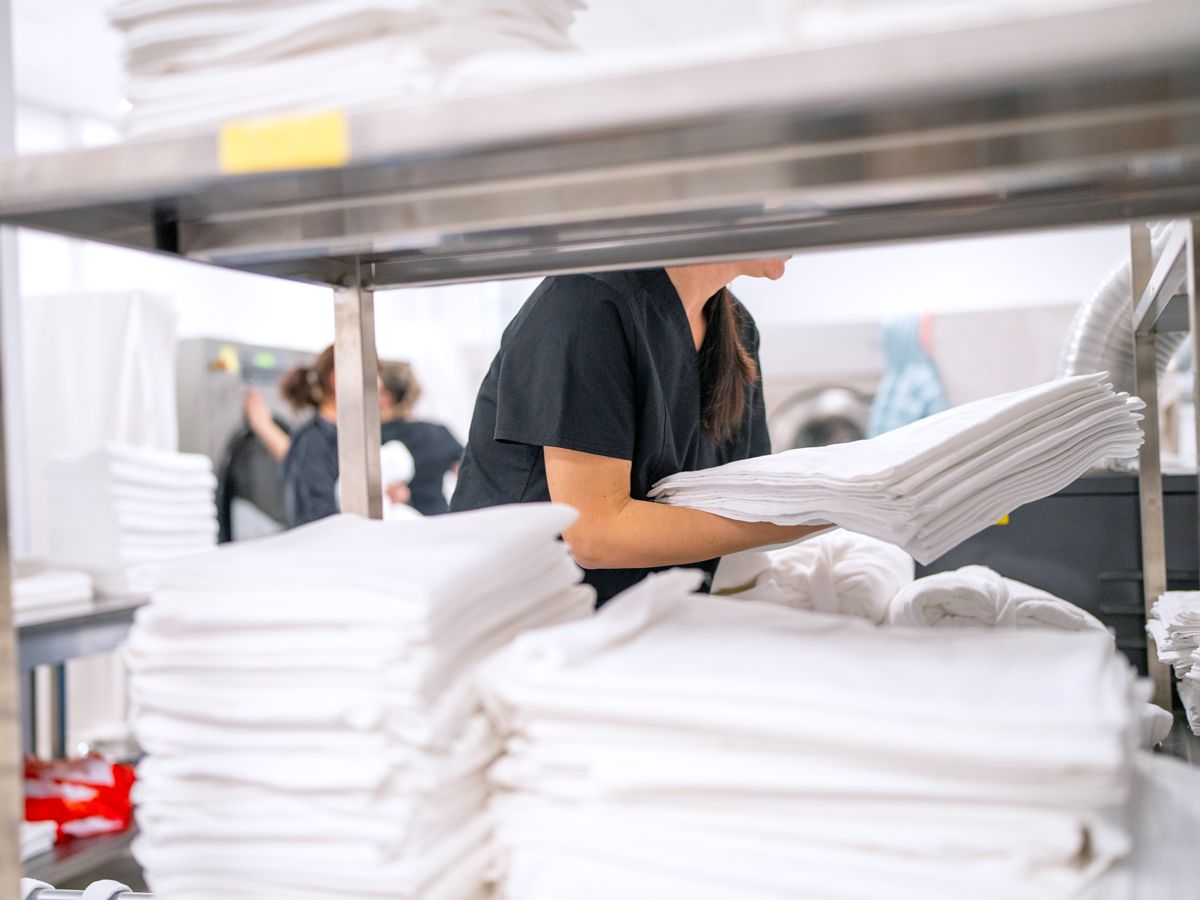 Hotel housekeeping staff picking up bedding