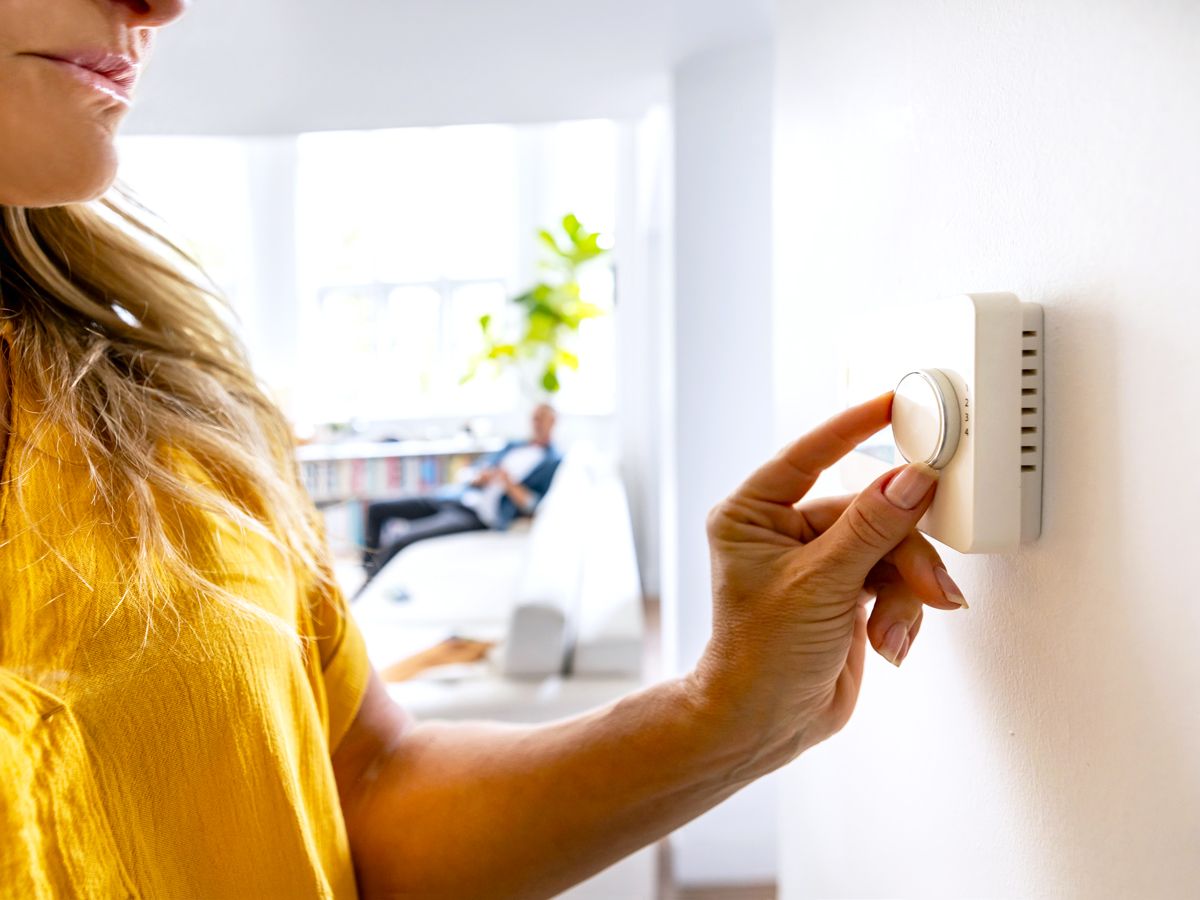Person adjusting thermostat