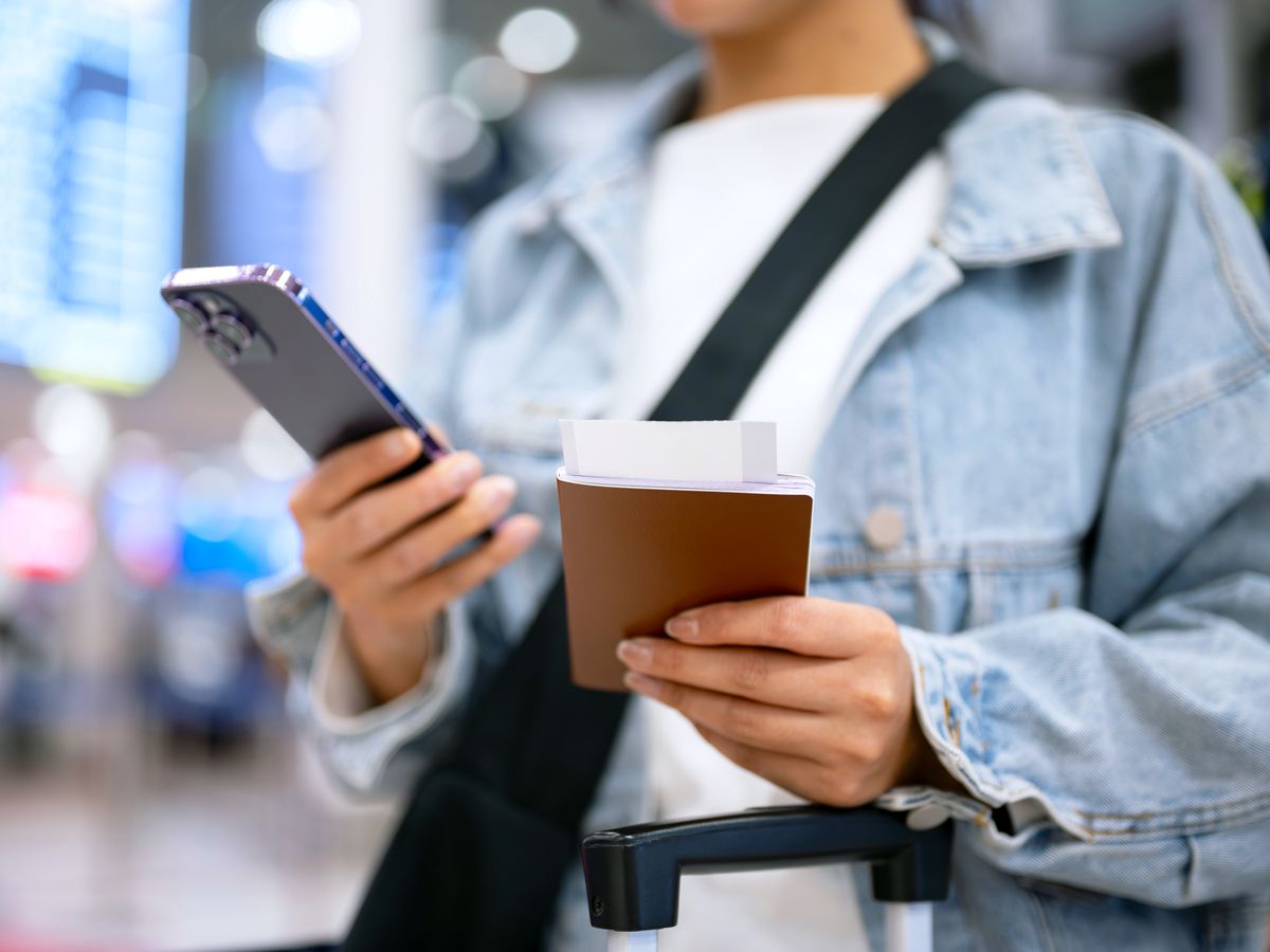 Traveler holding passport and phone