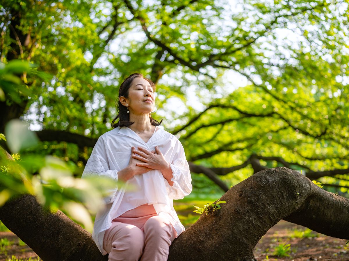Person meditating in forest
