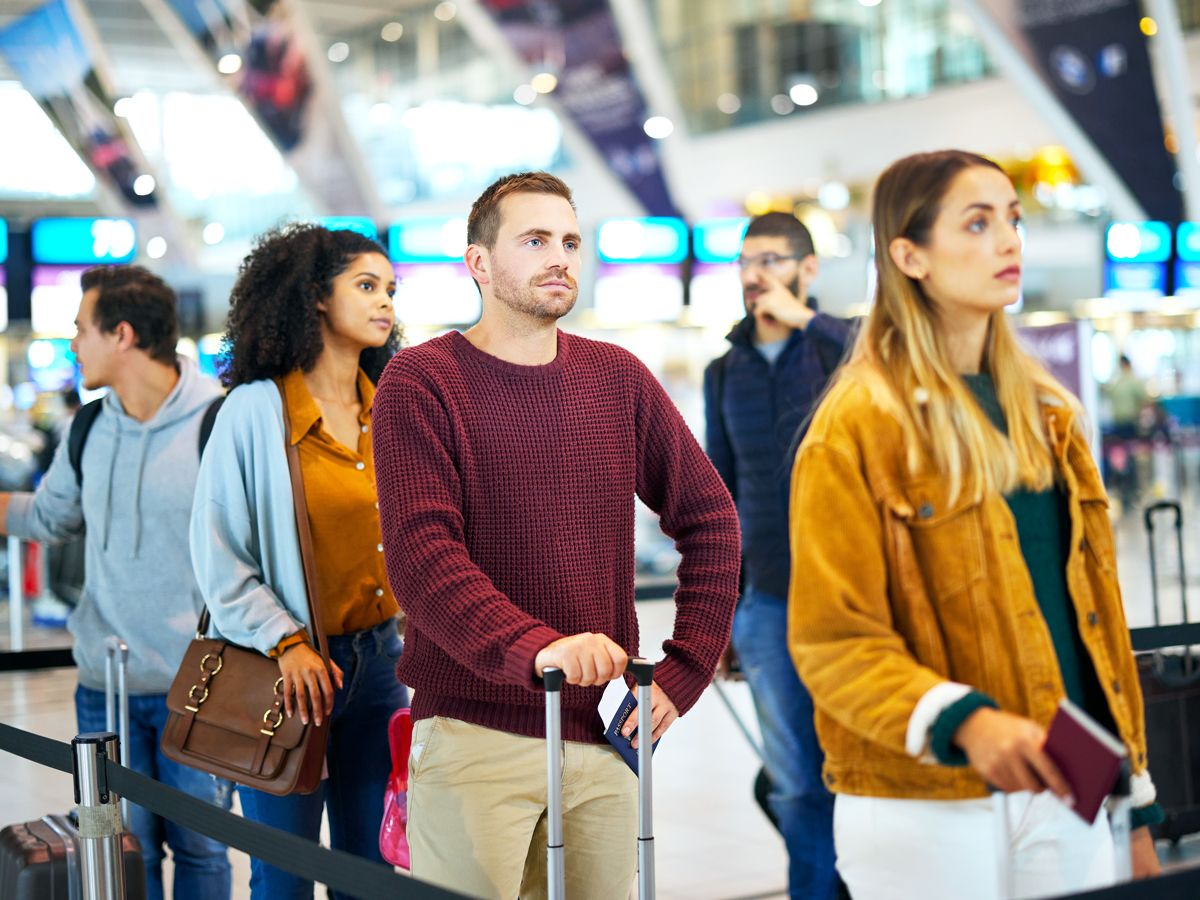 Airline passengers standing in line at airport