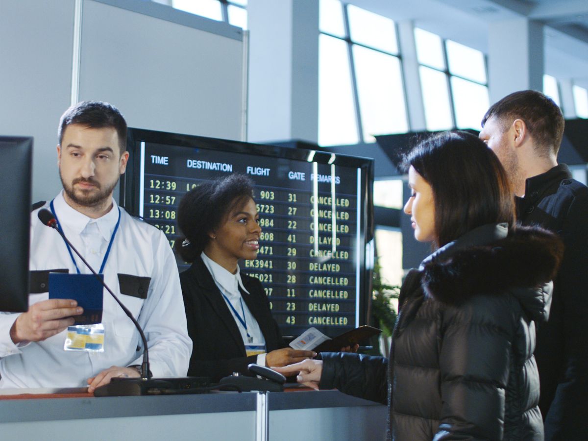 Gate agents inspecting tickets and documents at boarding gate