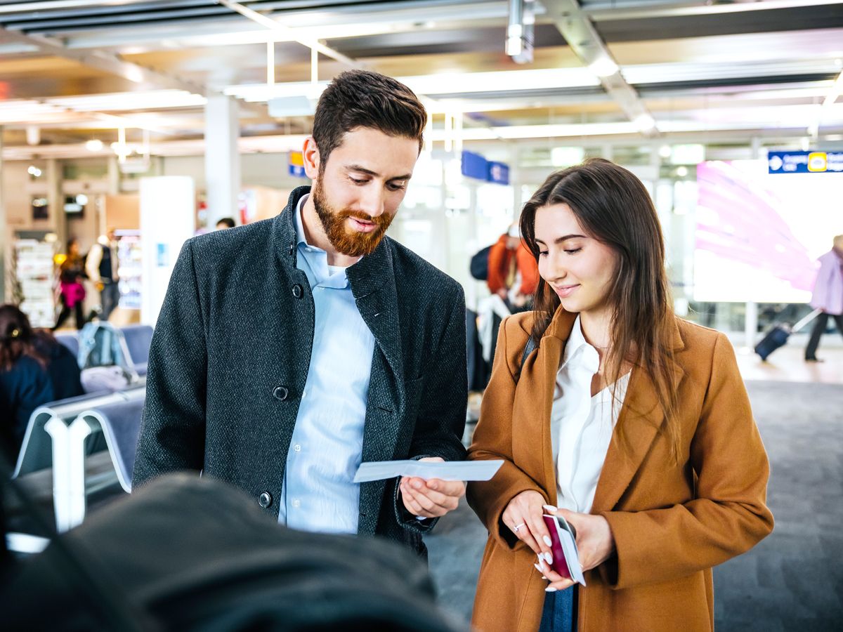Passengers looking at boarding passes in airport