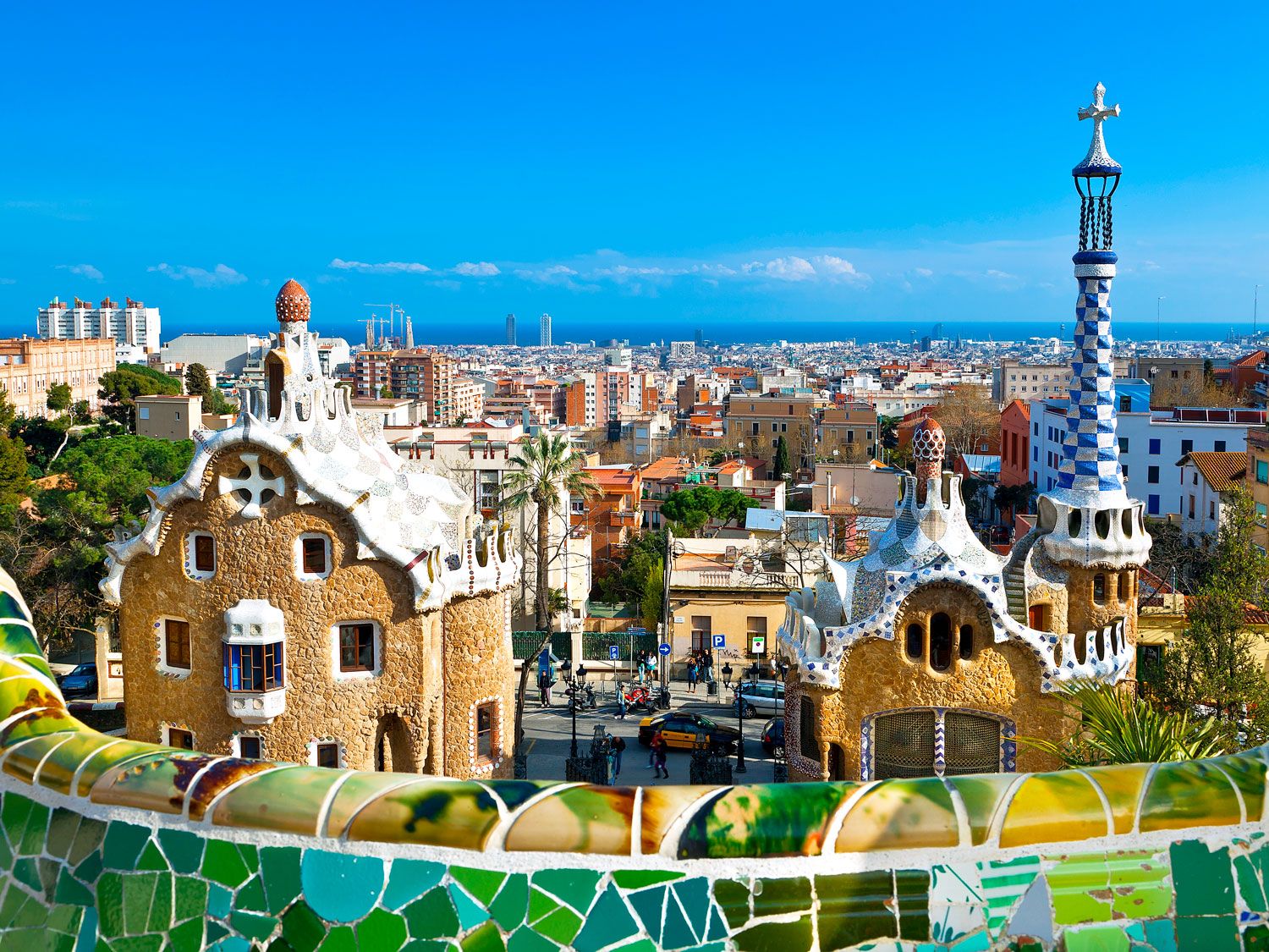 Colorful mosaics and architecture of Park Güell overlooking Barcelona skyline