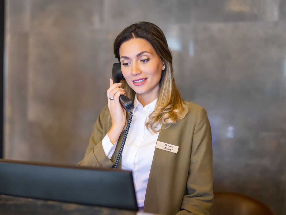 Hotel front desk employee speaking on phone