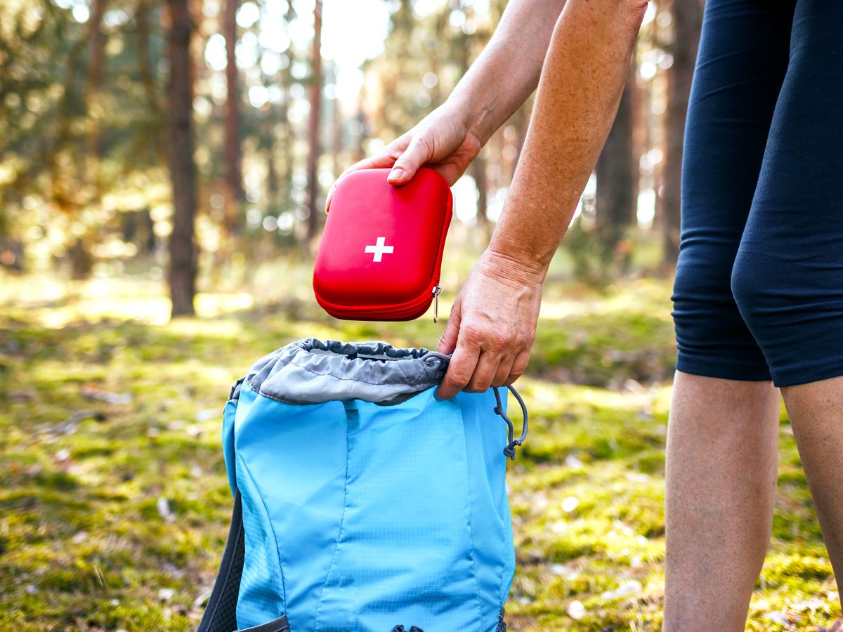 Person placing first-aid kit in bag