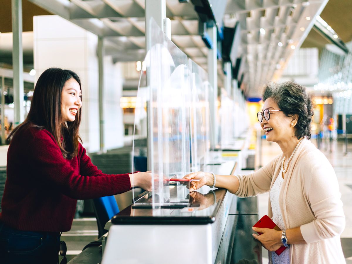 Airline employee and passenger at airport check-in desk