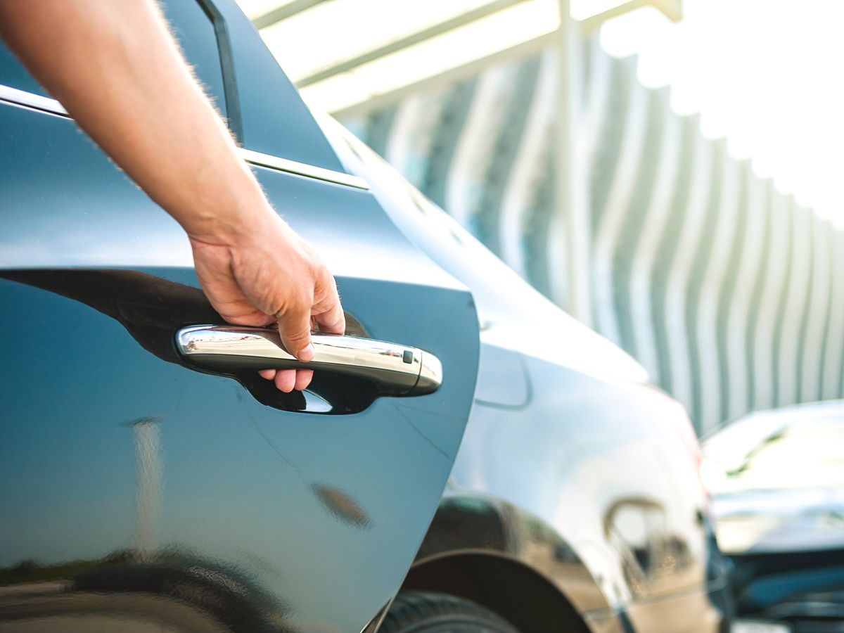 Close-up image of person opening car door