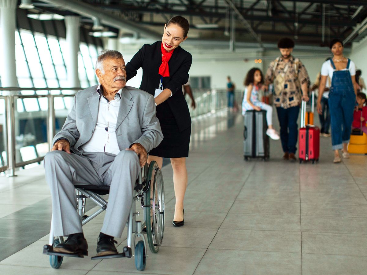 Airline employee assisting passenger using wheelchair