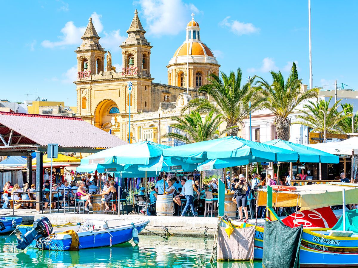 Waterfront restaurant patio with church in background in Malta