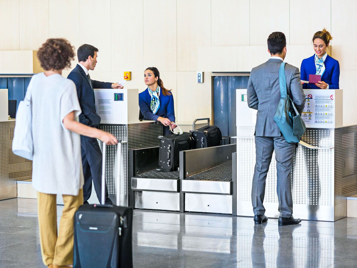 Passengers waiting in line to check bags at airport