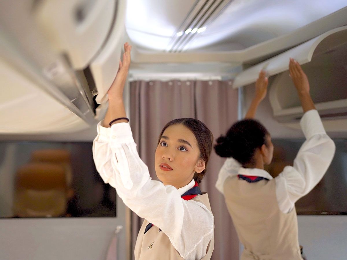 Flight attendants closing overhead bins on airplane
