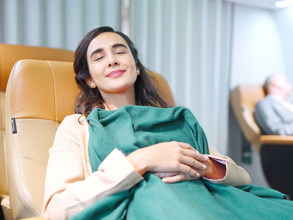 Airline passenger reclined in seat with blanket