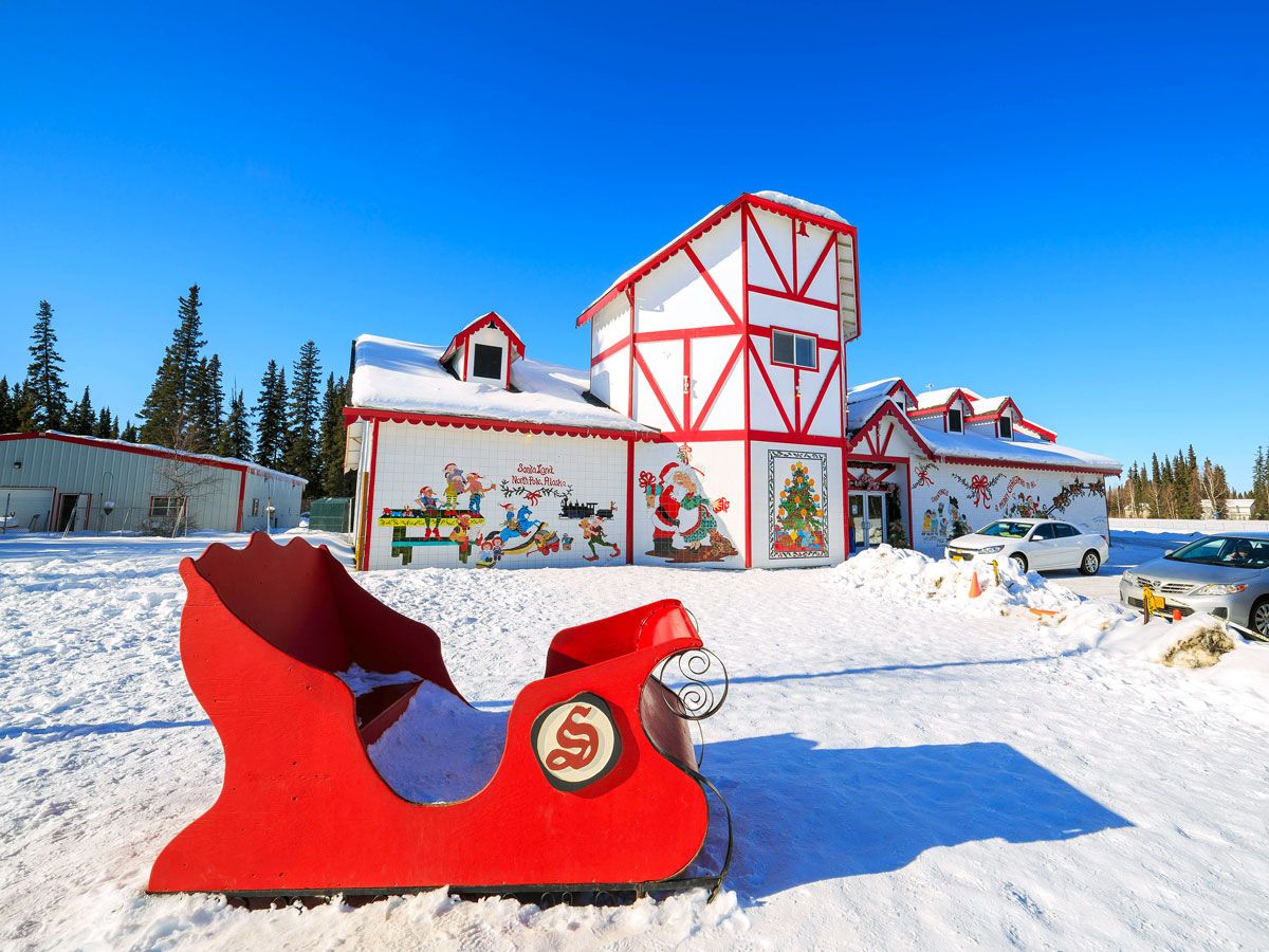 Santa Claus-themed building and sled seen on snowy day in North Pole, Alaska