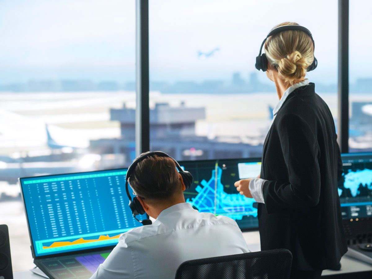 Air traffic controllers viewing airfield from control tower