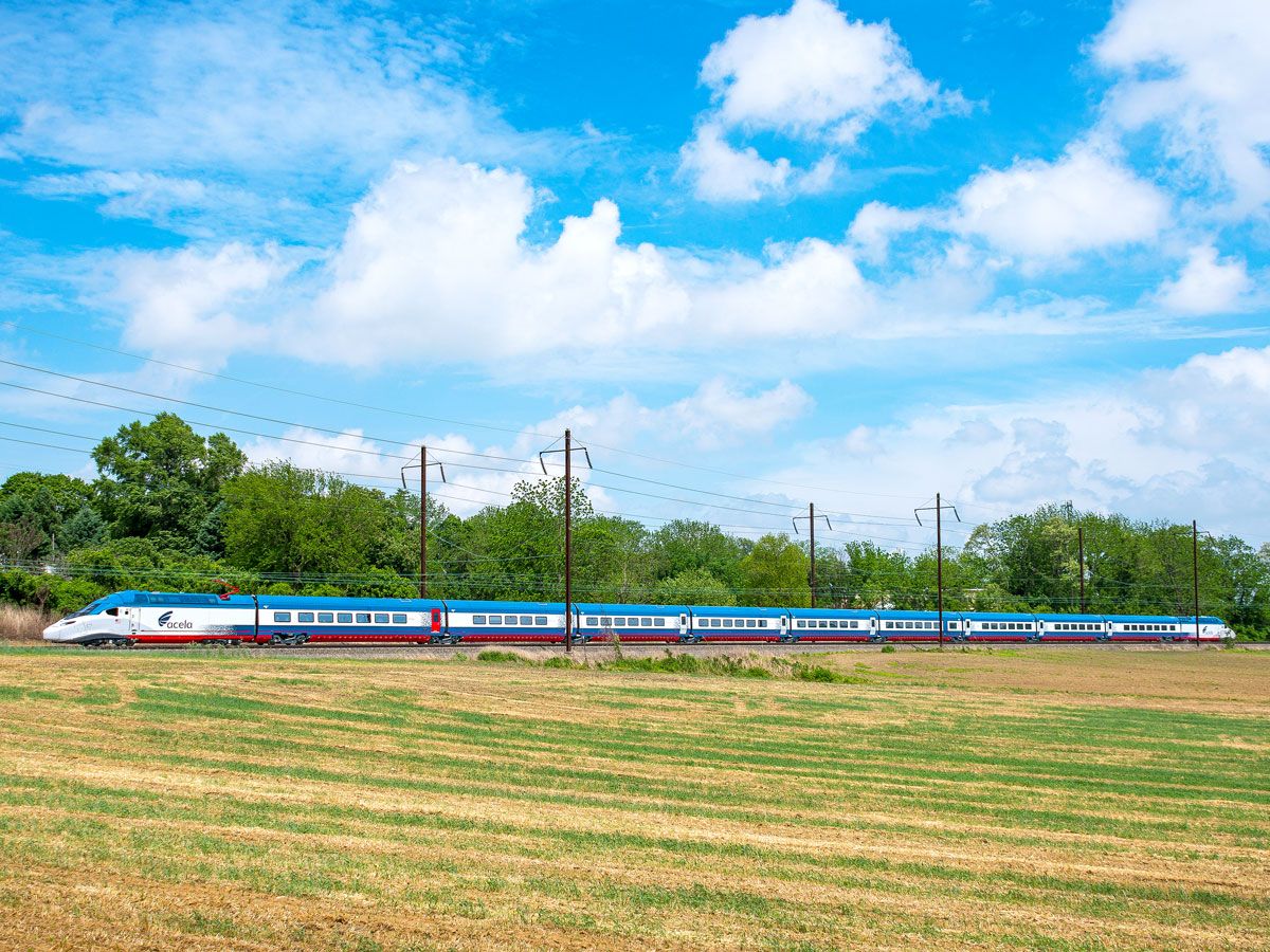 Amtrak train traveling past open field
