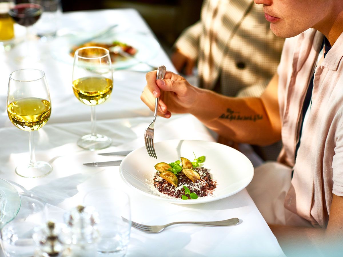 Diner with salad and wine on white tablecloth