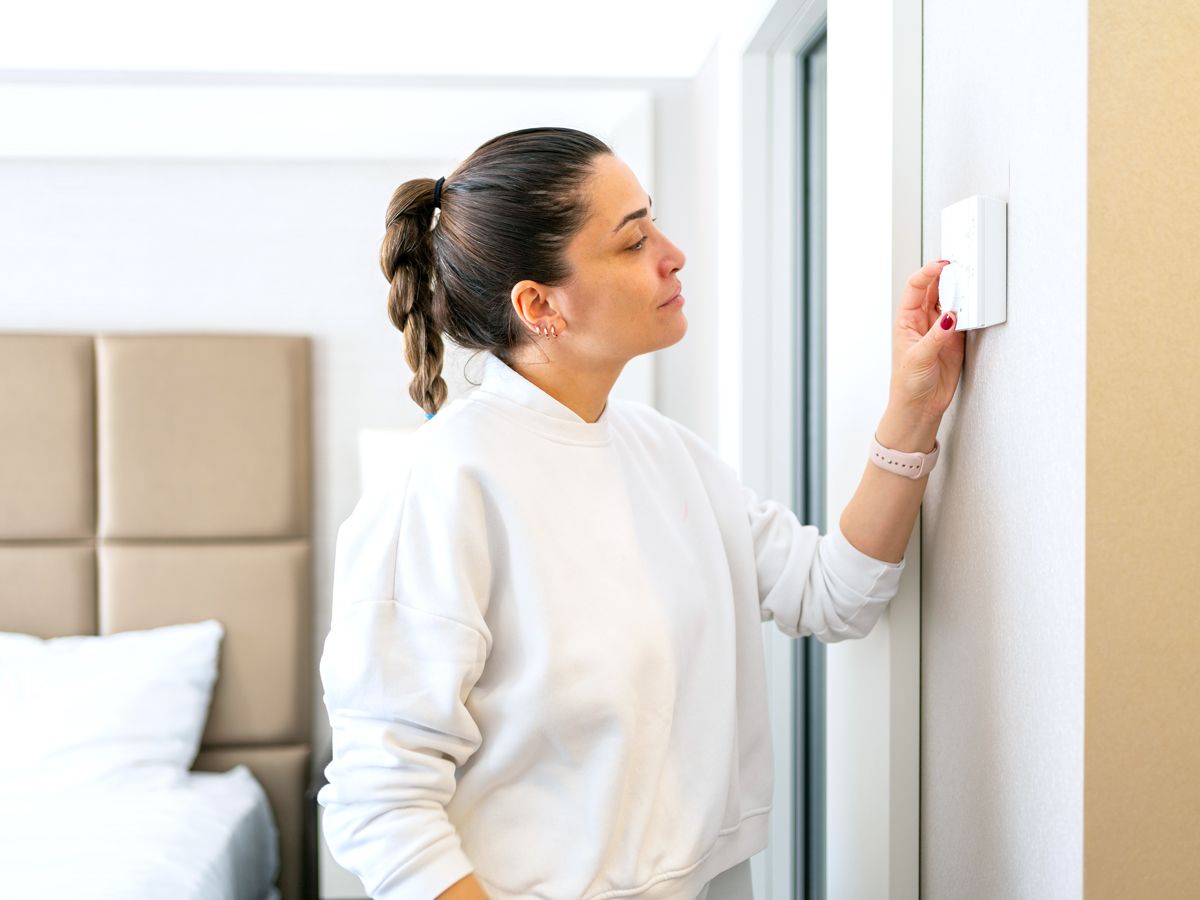 Hotel guest adjusting thermostat