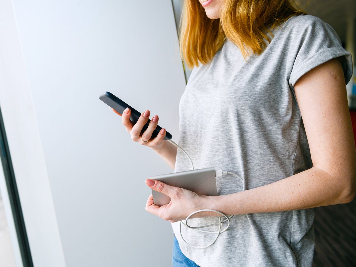 Person using portable charger to power cellphone