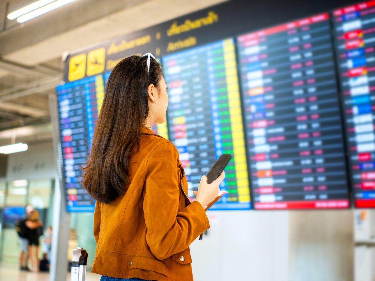 Traveler looking at departures and arrivals screen in airport