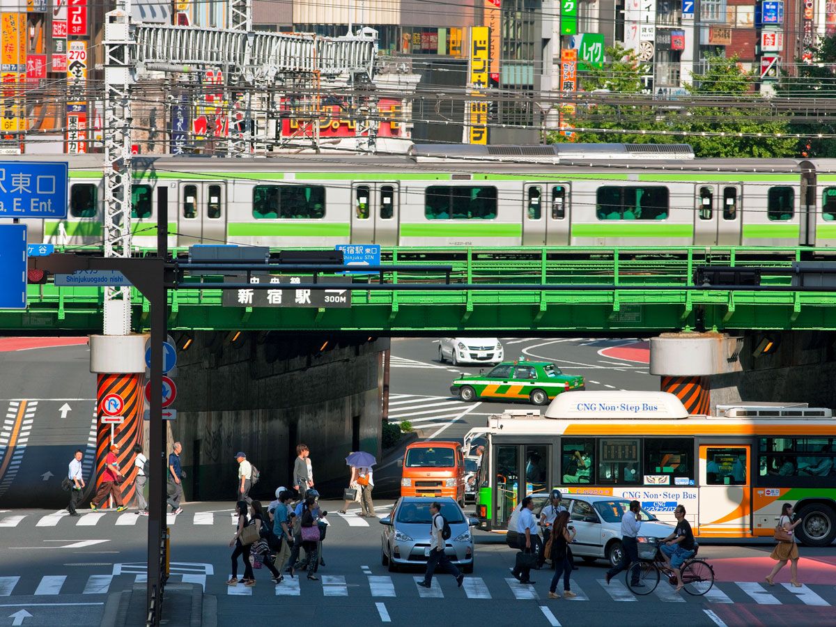 Train crossing over busy street in Tokyo, Japan