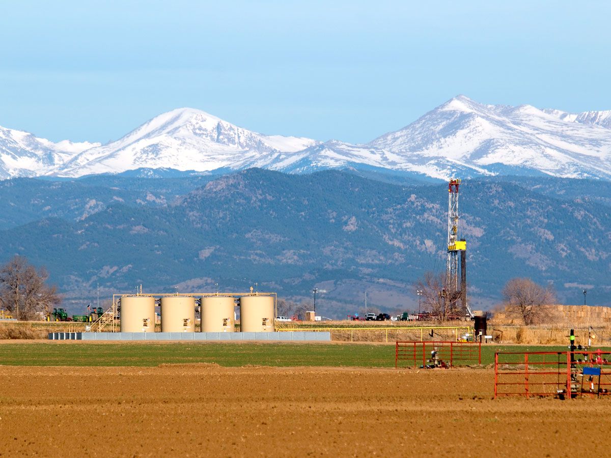 Oil drill in front of snow-covered peaks in Colorado
