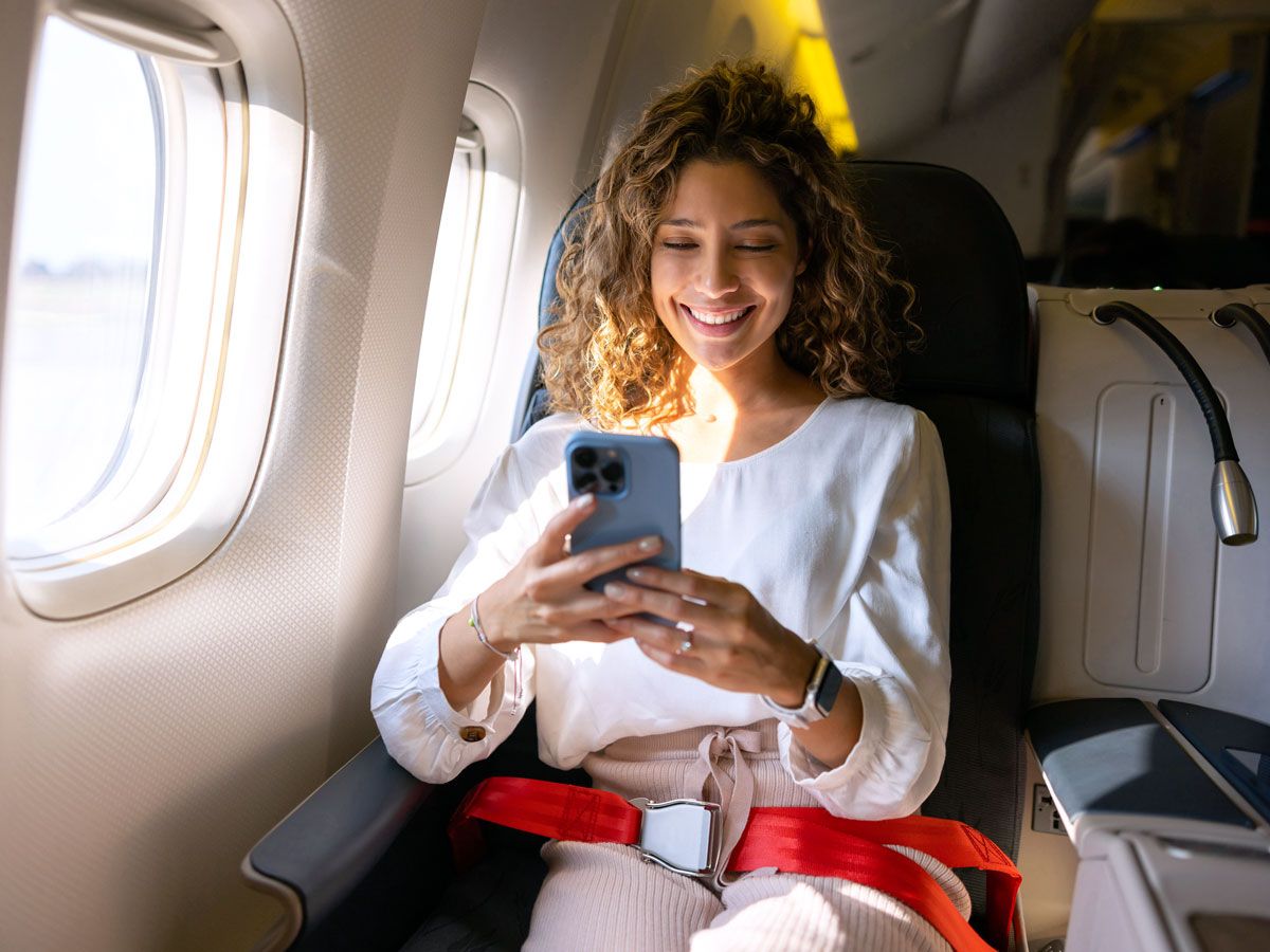 Traveler on cellphone in business-class seat