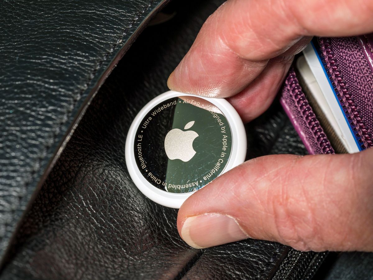 Person holding Apple AirTag inside bag