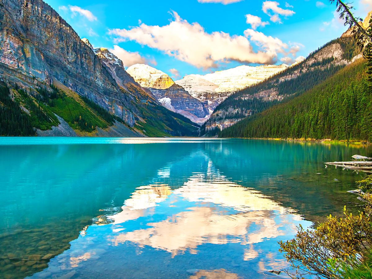 Reflections of clouds and mountains on Lake Louise in Alberta, Canada