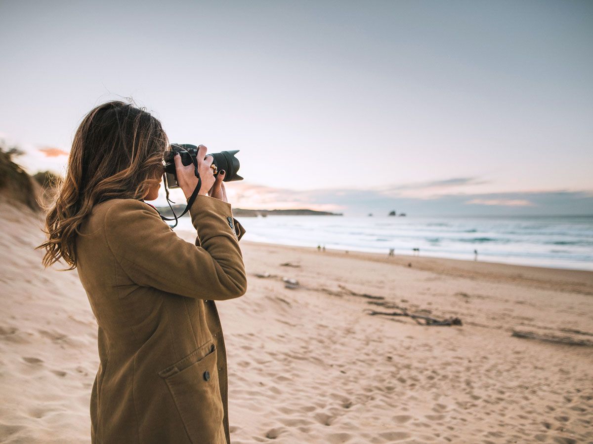 Woman taking photograph on beach