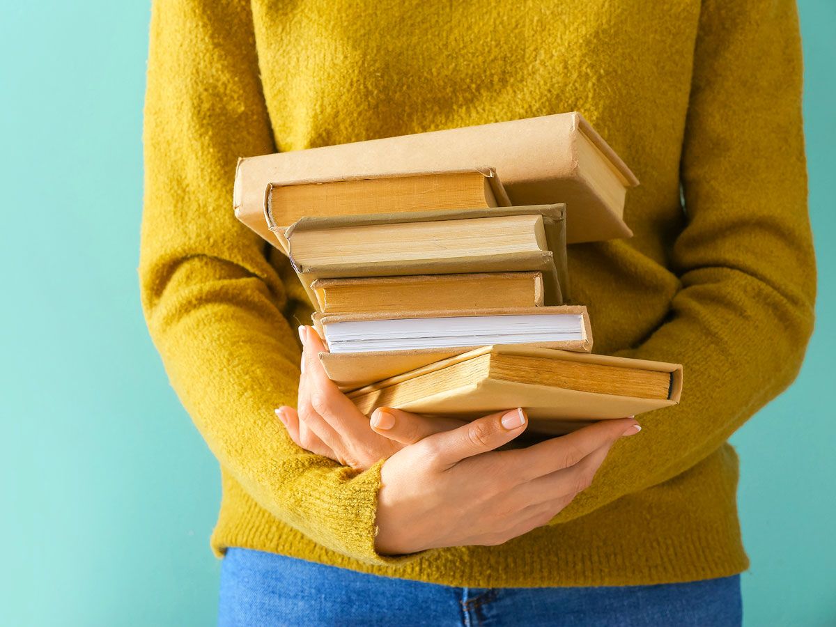 Person holding stack of books