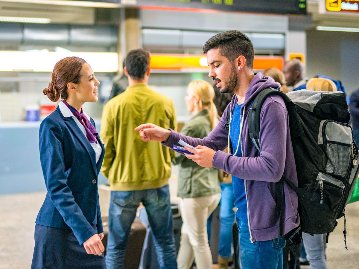 Traveler speaking with airport staff member