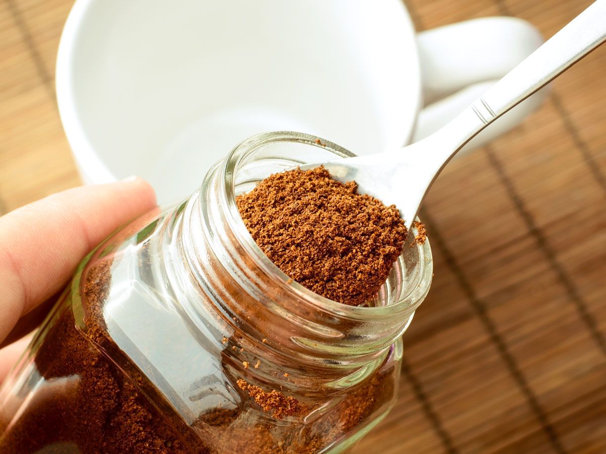 Person taking spoonful of spice from jar