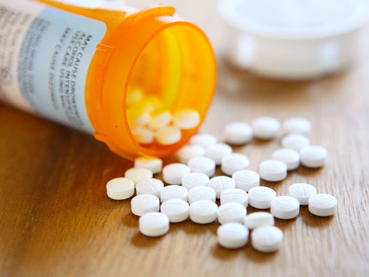 Pills spilling out of pill bottle onto table
