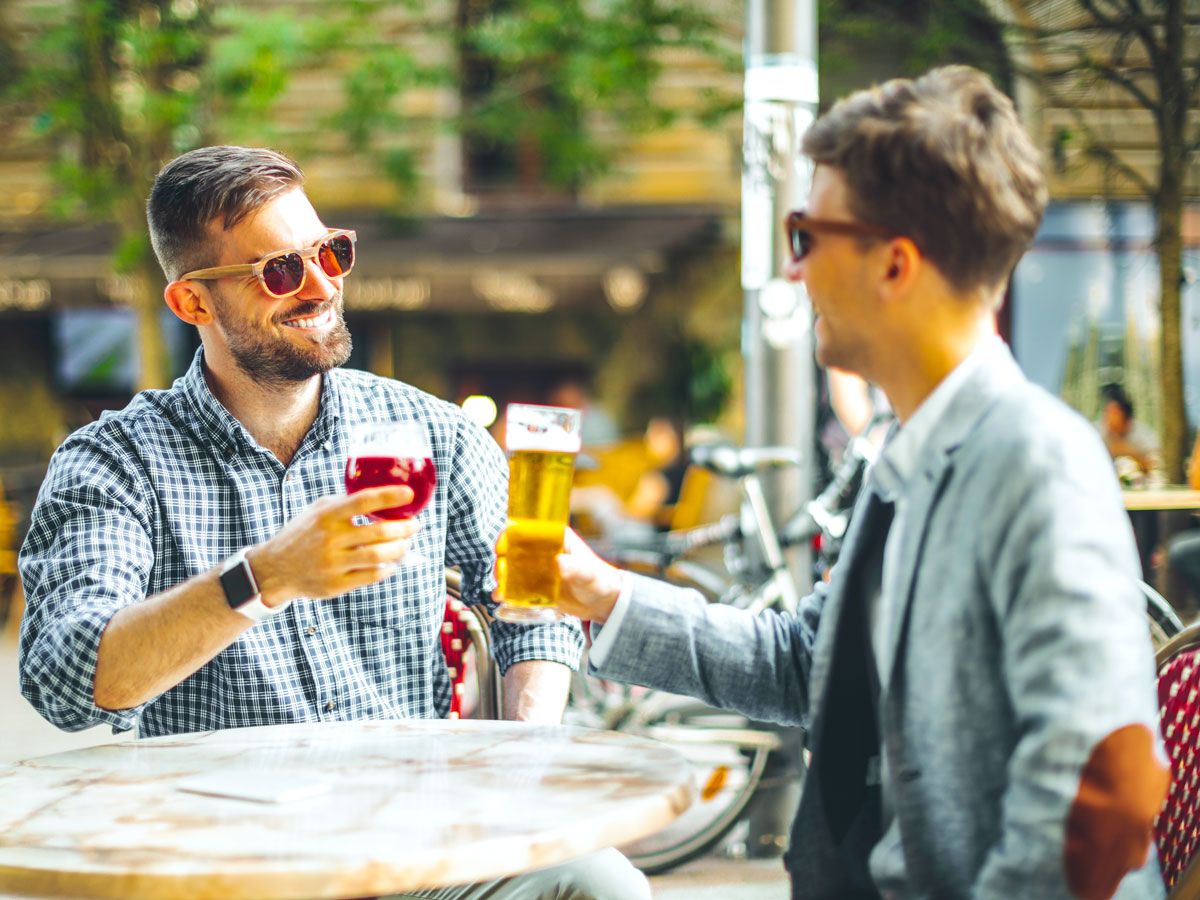 Two men drinking beer on patio