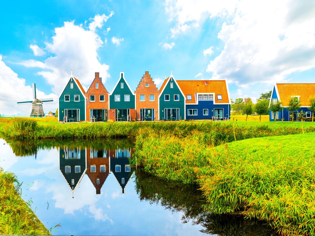 Colorful row houses and windmill along river in the Netherlands