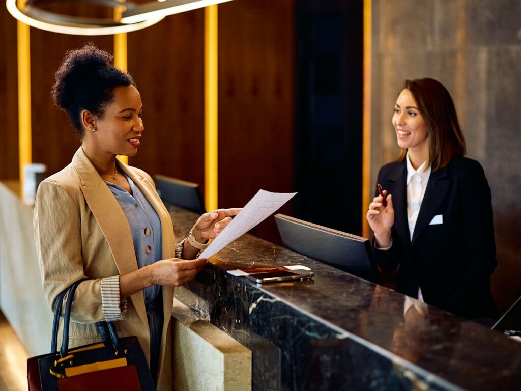 Hotel guest reviewing folio at front desk