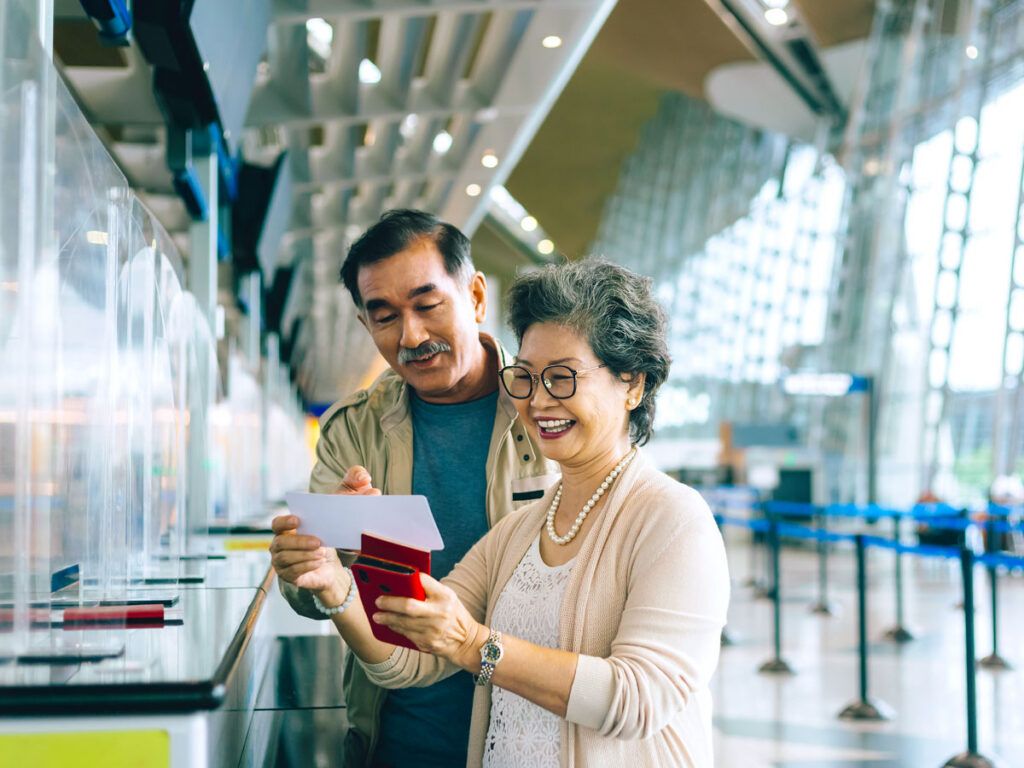 Couple reviewing boarding pass at ticket counter