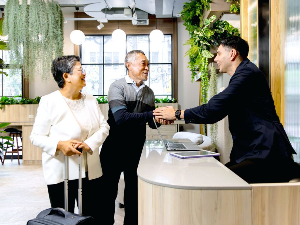 Couple interacting with hotel front desk employee